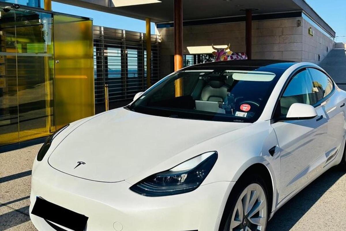 um carro branco estacionado em frente a um prédio