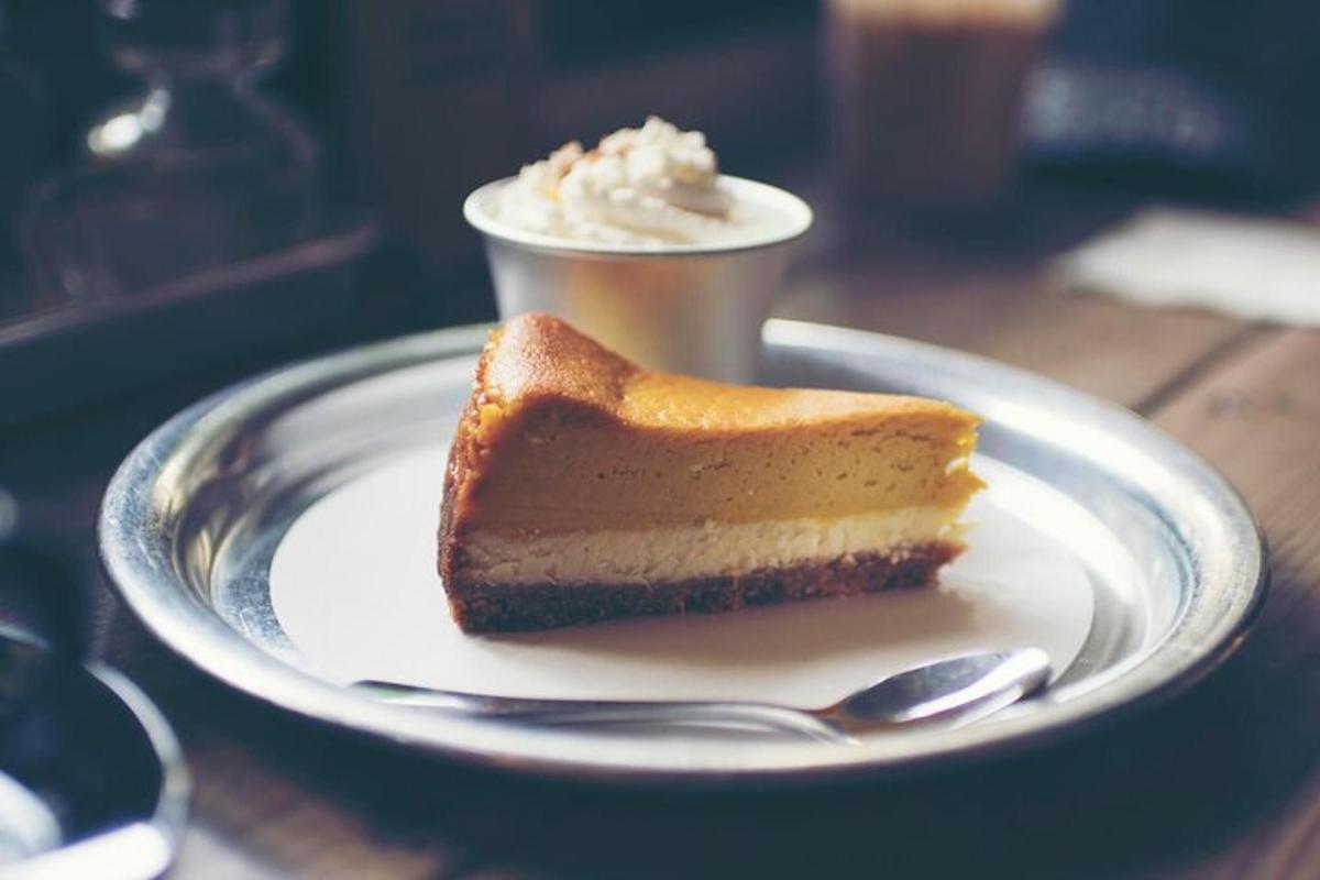 a piece of cake on a plate with a cup of coffee