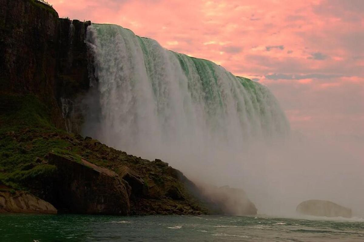 ein Wasserfall an der Seite eines Berges mit einem bewölkten Himmel