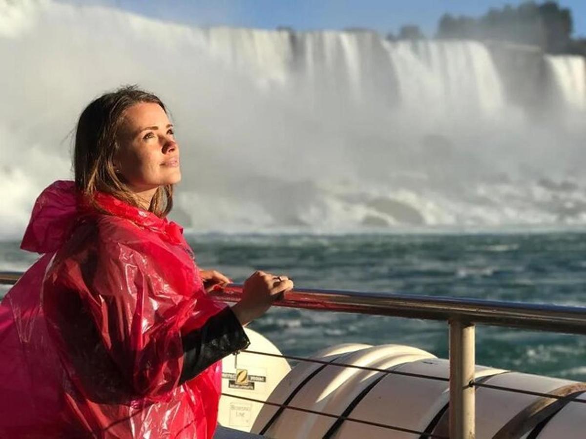 uma mulher em um barco em frente a uma cachoeira