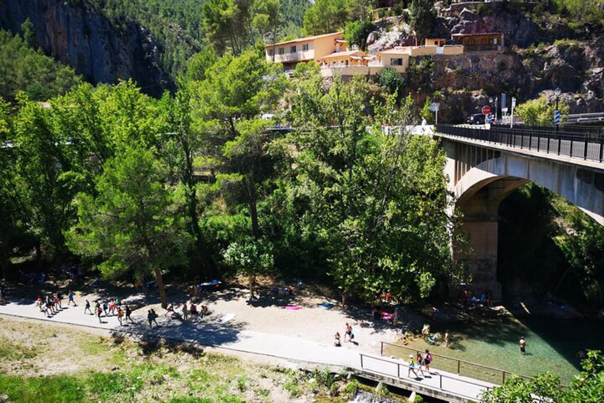 um grupo de pessoas caminhando na calçada sob uma ponte