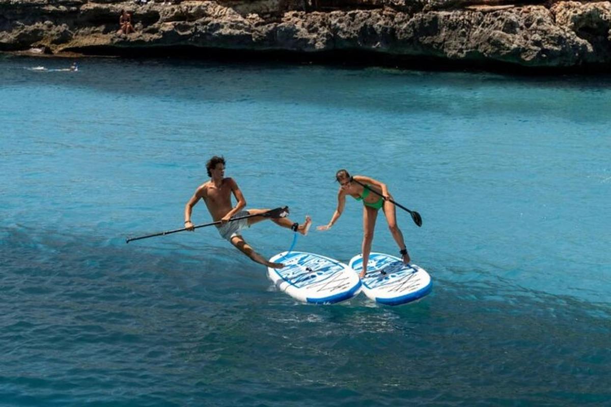 due persone sono in piedi su tavole da paddle in acqua