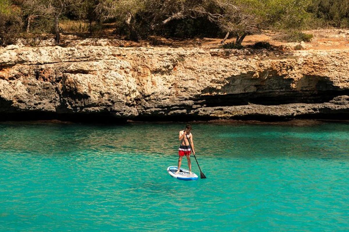un bărbat care stă pe o placă de paddle în apă