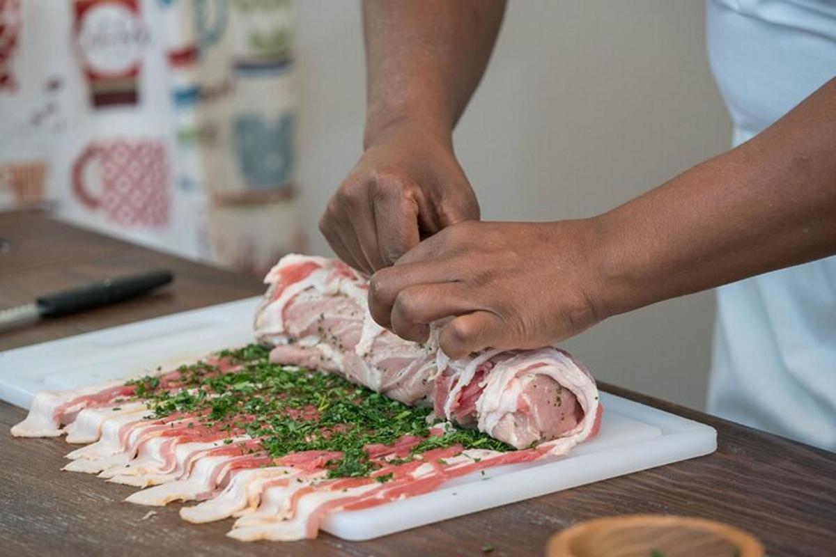 uma pessoa cortando um pedaço de carne em uma tábua de corte