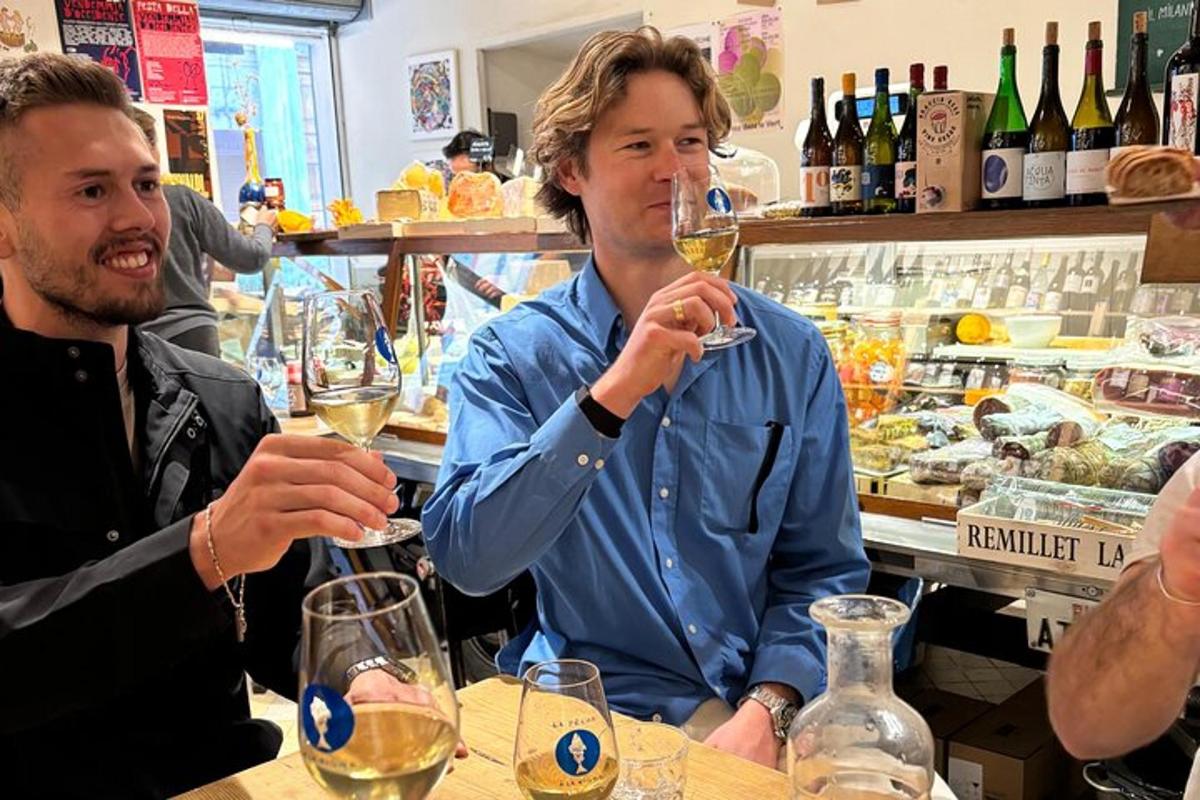 Dos hombres sentados en un bar bebiendo vino