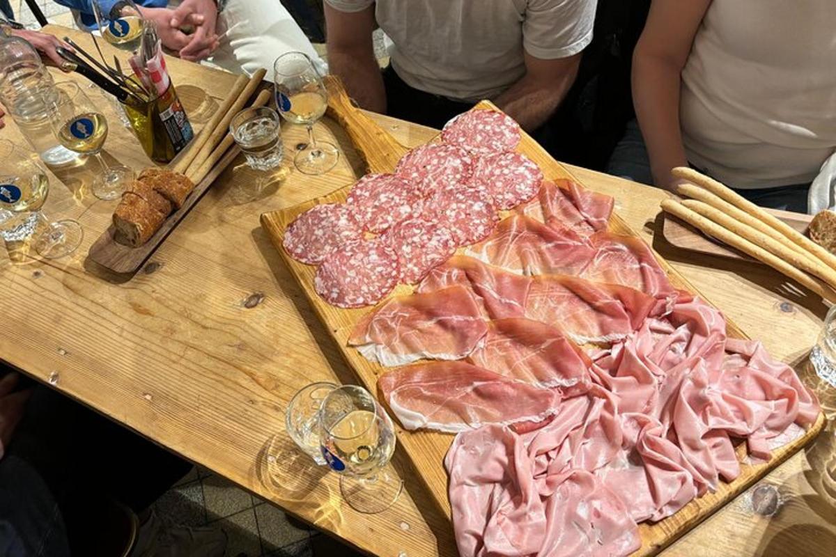 ein Holztisch mit Fleisch und Weingläsern