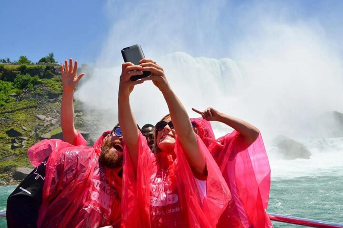 two people on a boat taking a picture of a waterfall