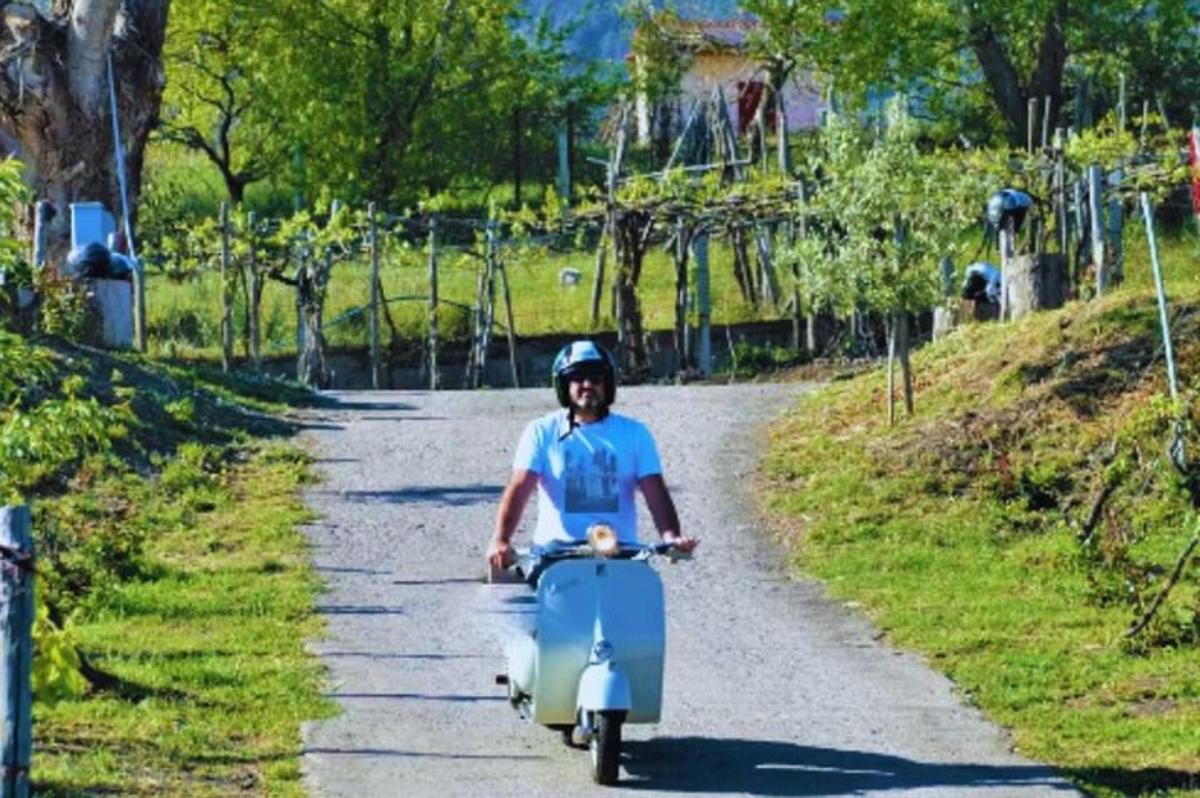 maður hjólar á vespu niður götu