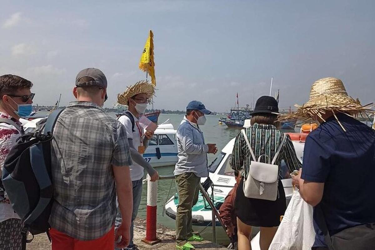 un gruppo di persone in piedi vicino a una barca in acqua