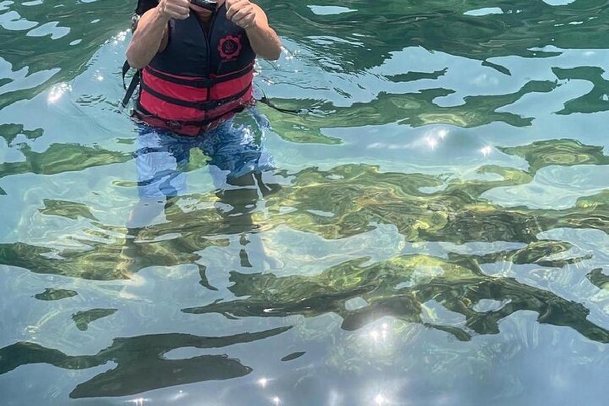 moški stoji v vodi in fotografira