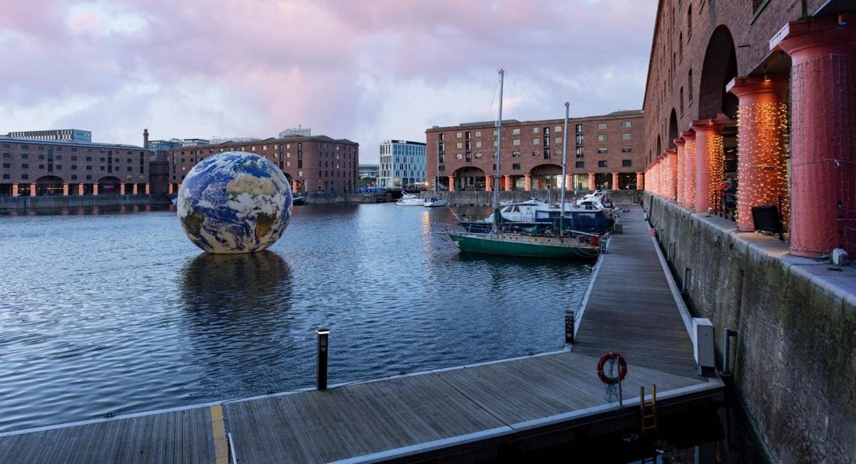 a dock with a large sculpture next to a river