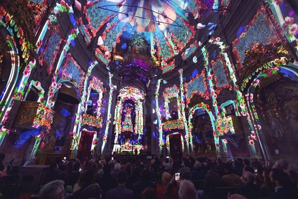 a large group of people in a church with christmas lights