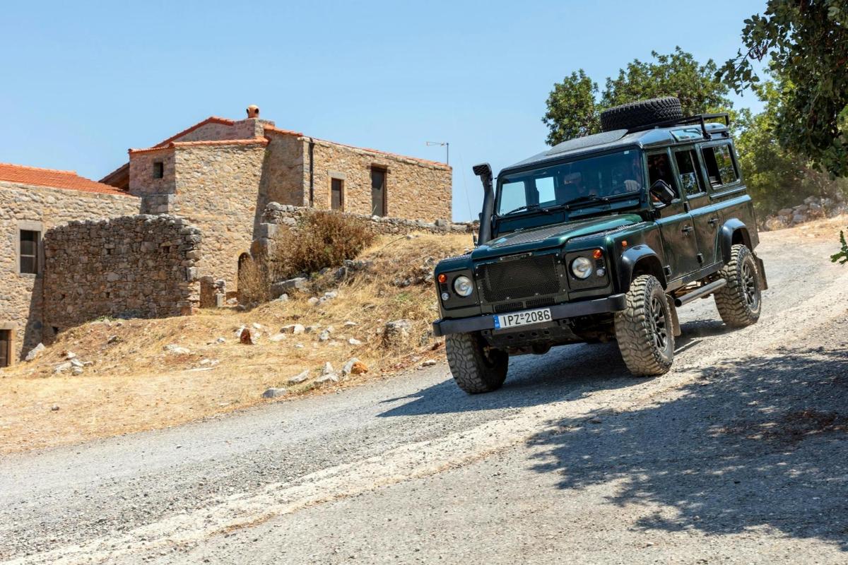 a green jeep driving down a dirt road