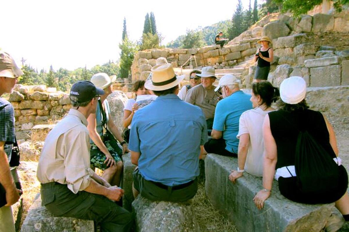 skupina lidí sedících na kamenné zdi