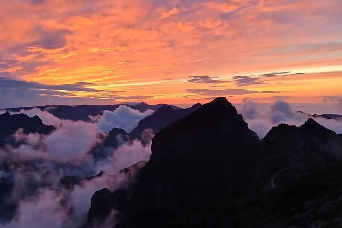 un apus de soare în vârful unui munte cu nori