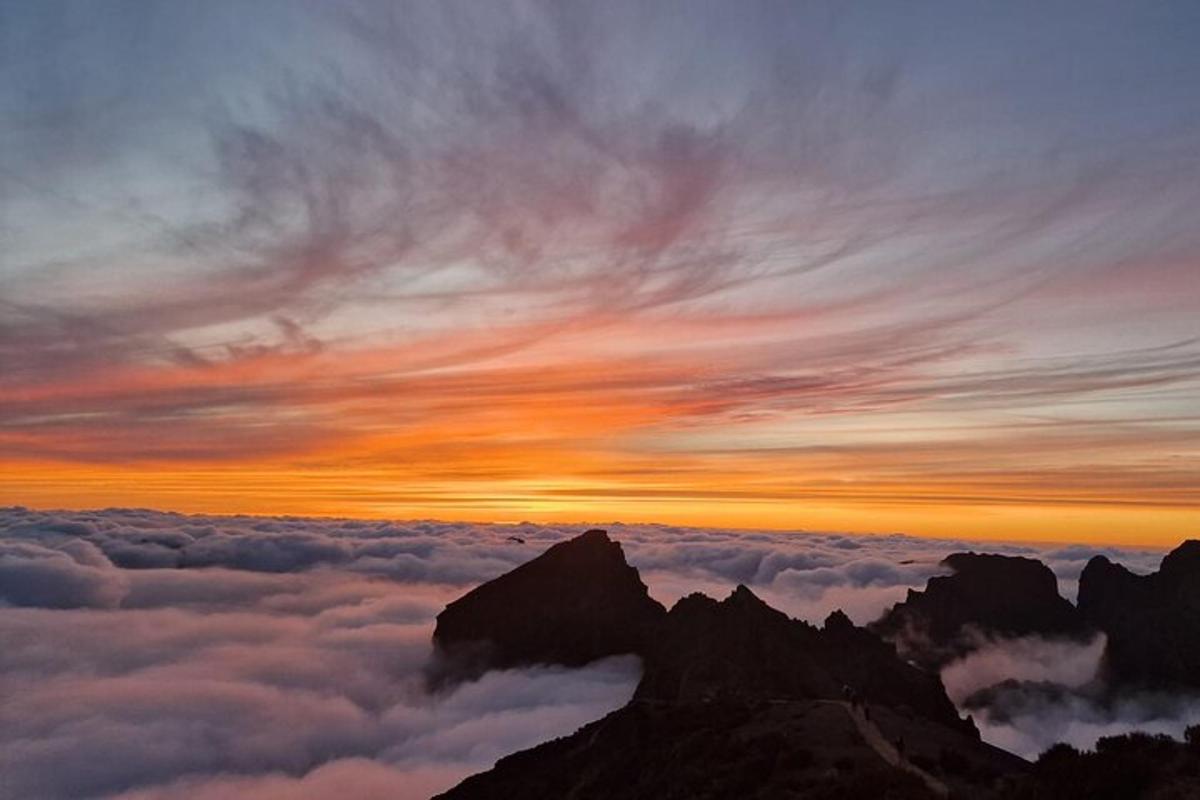 un apus de soare în vârful unui munte cu nori