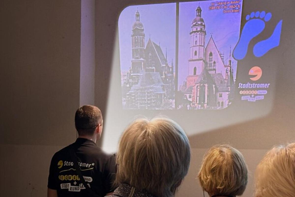 um homem em pé na frente de um grupo de pessoas assistindo a uma apresentação