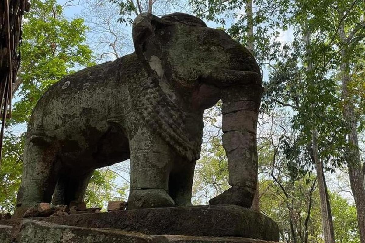 o statuie a unui elefant care stă pe o stâncă