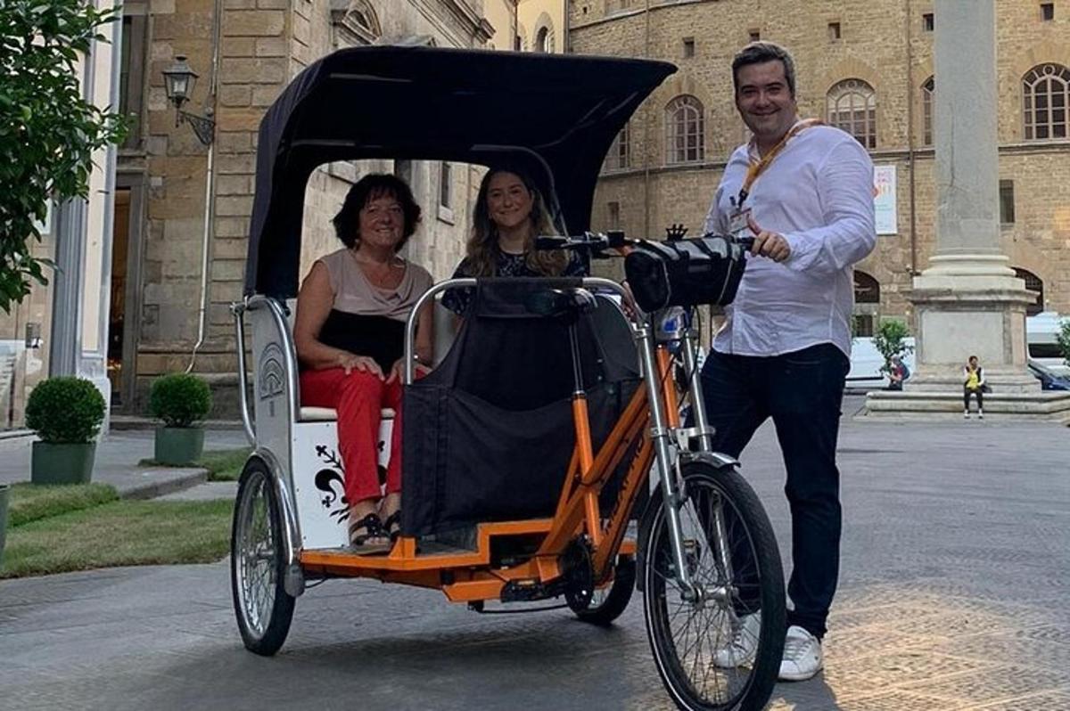 Egy férfi biciklit tol, két nő hintóban