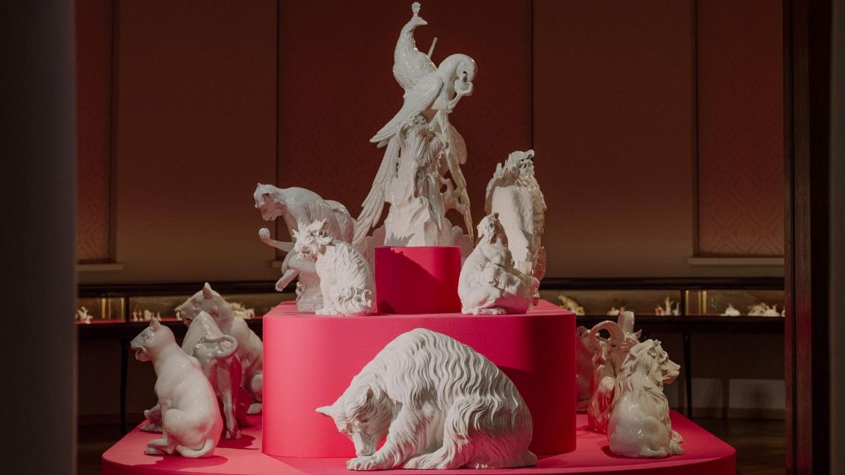 a pink cake with animals on top of it