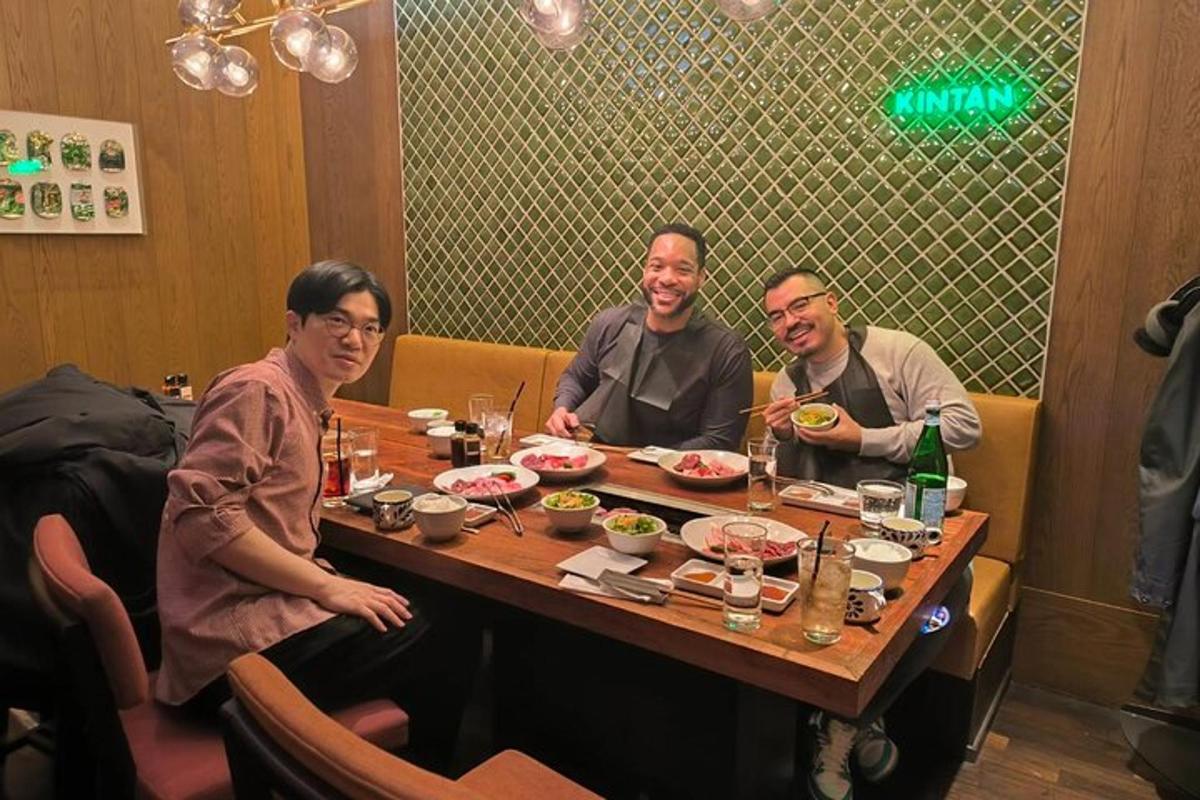 tiga orang duduk di meja makan makanan
