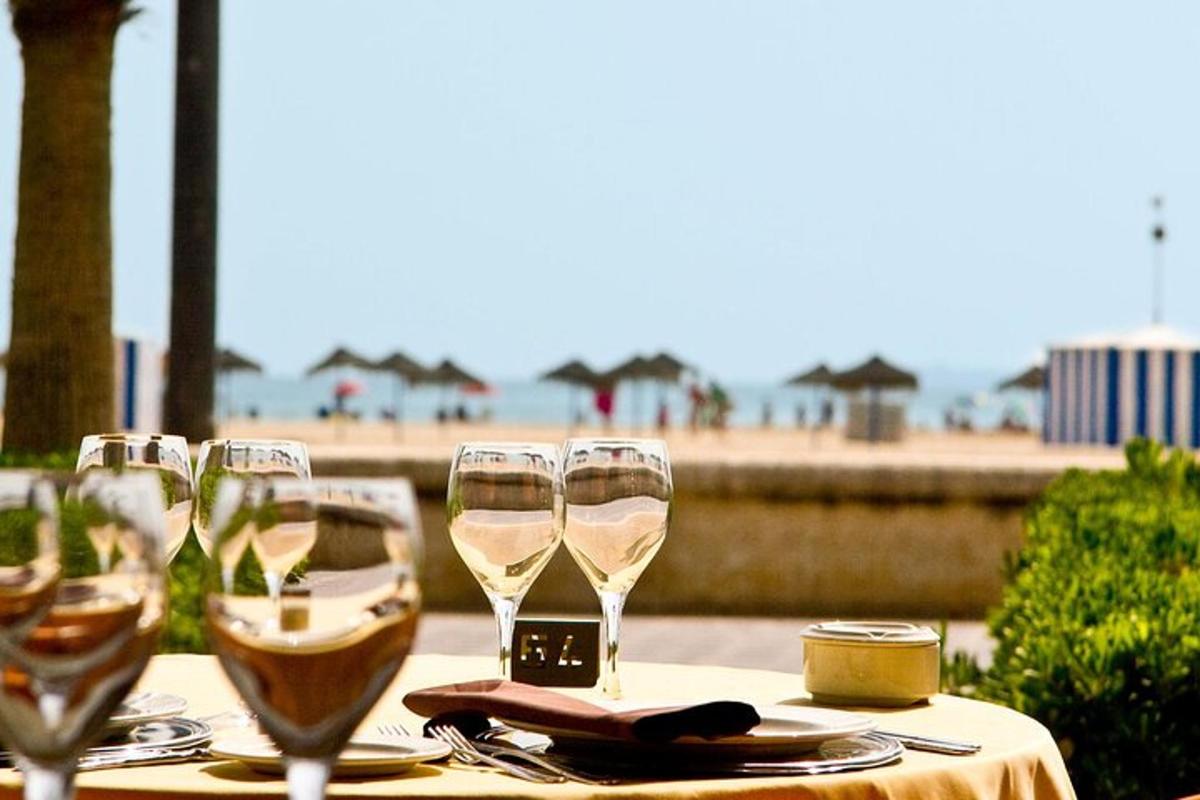 uma mesa com taças de vinho sobre uma mesa com a praia