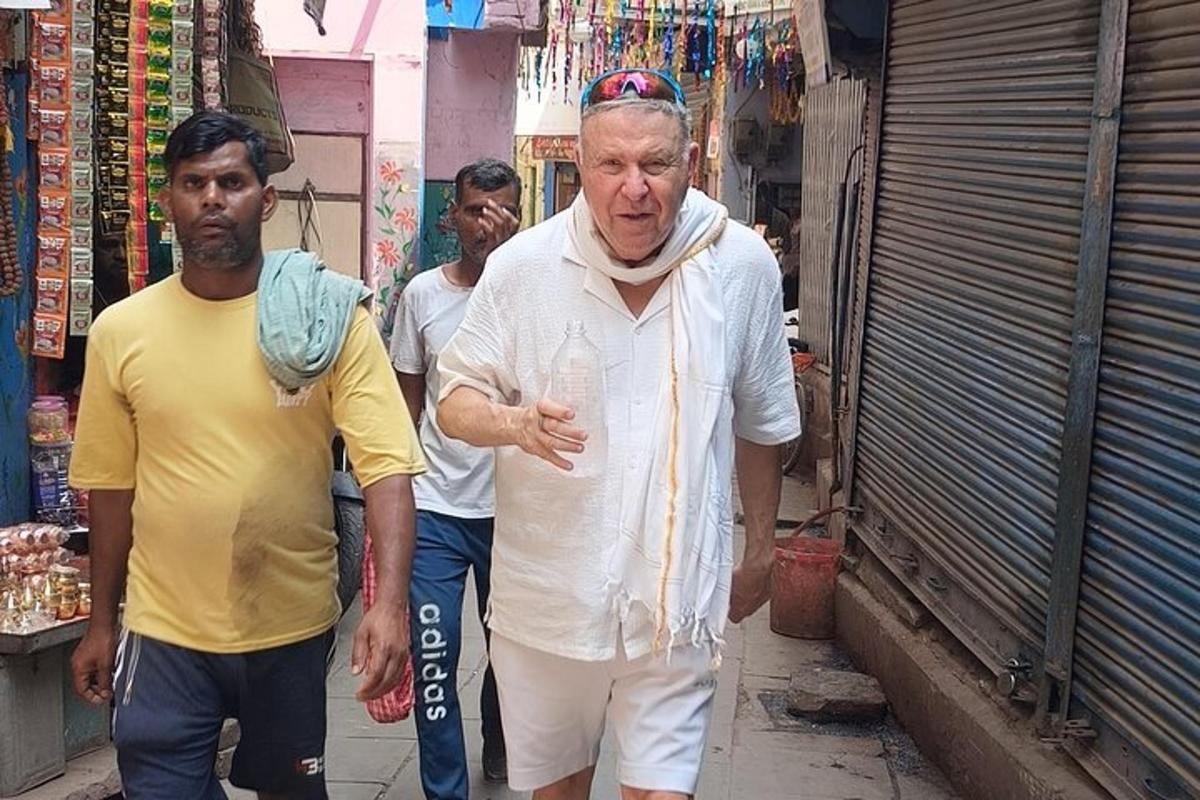a man walking down a street holding a glass