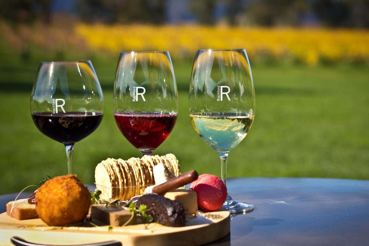 three glasses of wine sitting on a table with food