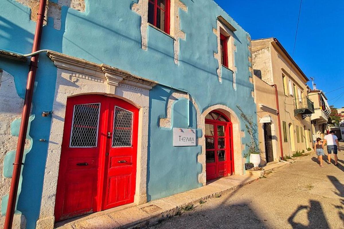 Ένα μπλε και κόκκινο κτίριο με κόκκινες πόρτες σε έναν δρόμο
