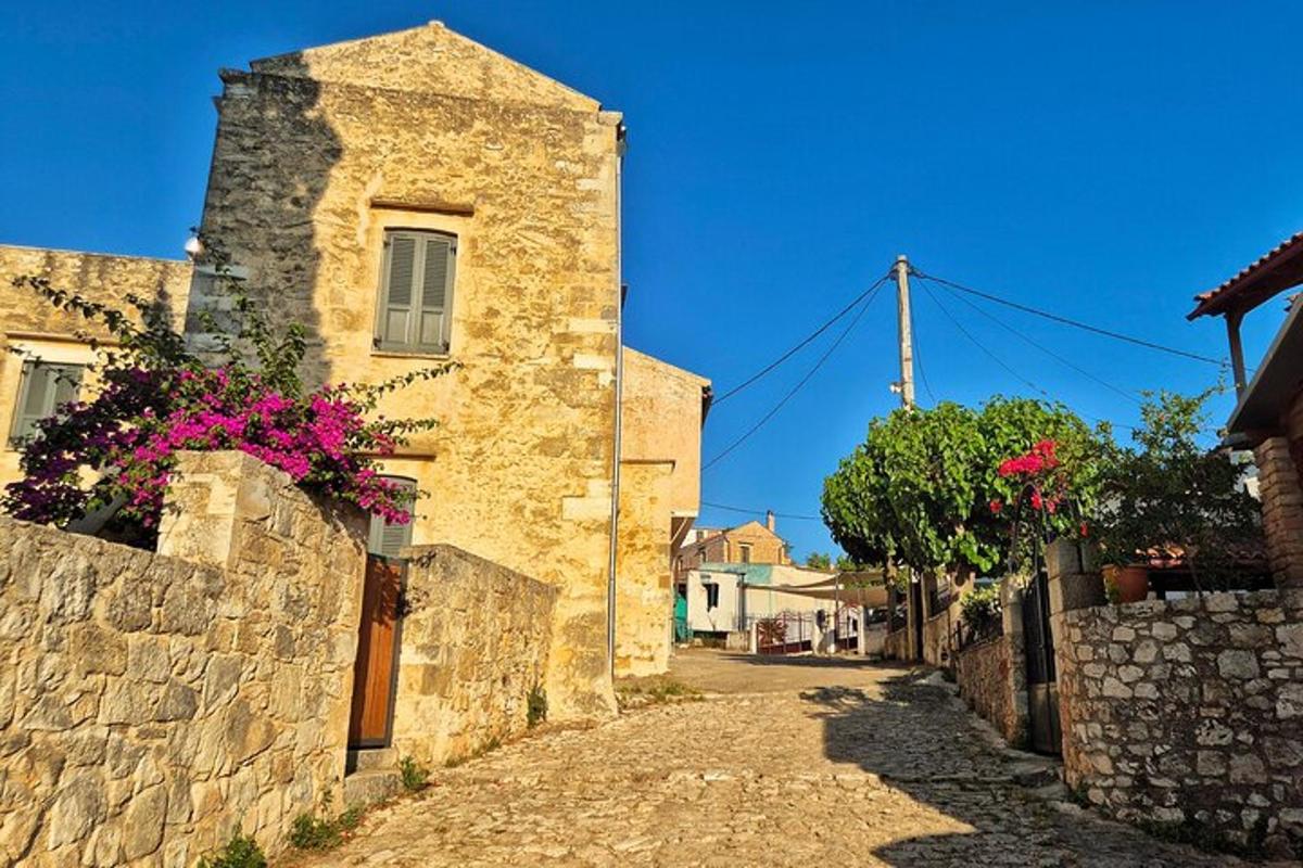 ένα πέτρινο κτίριο με λουλούδια στην άκρη ενός δρόμου