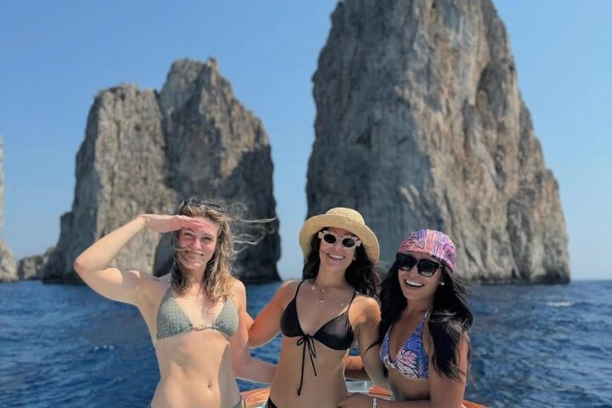 Þrjár konur í sundfötum á bát í vatninu