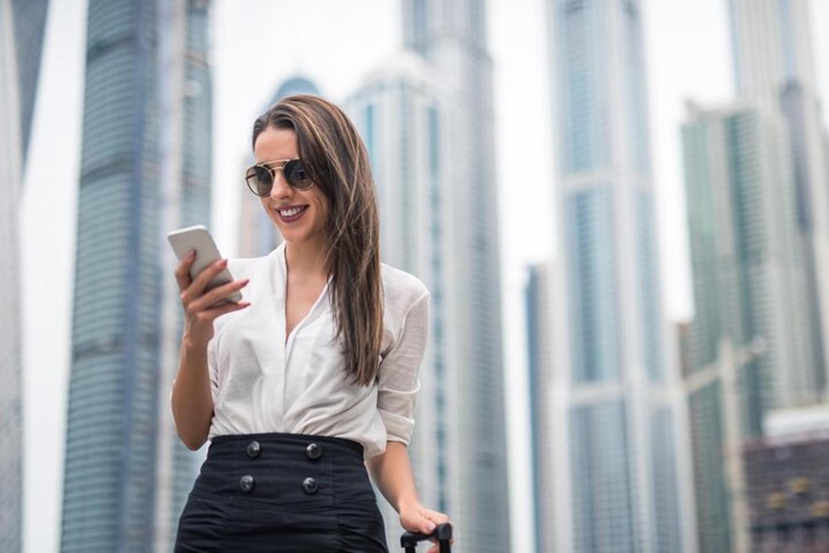 a woman is looking at her cell phone in a city