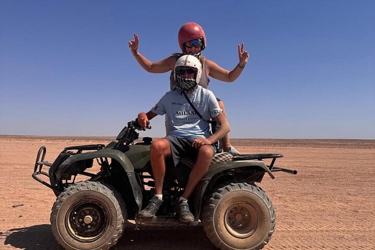 zwei Personen sitzen auf einem Wheeler in der Wüste