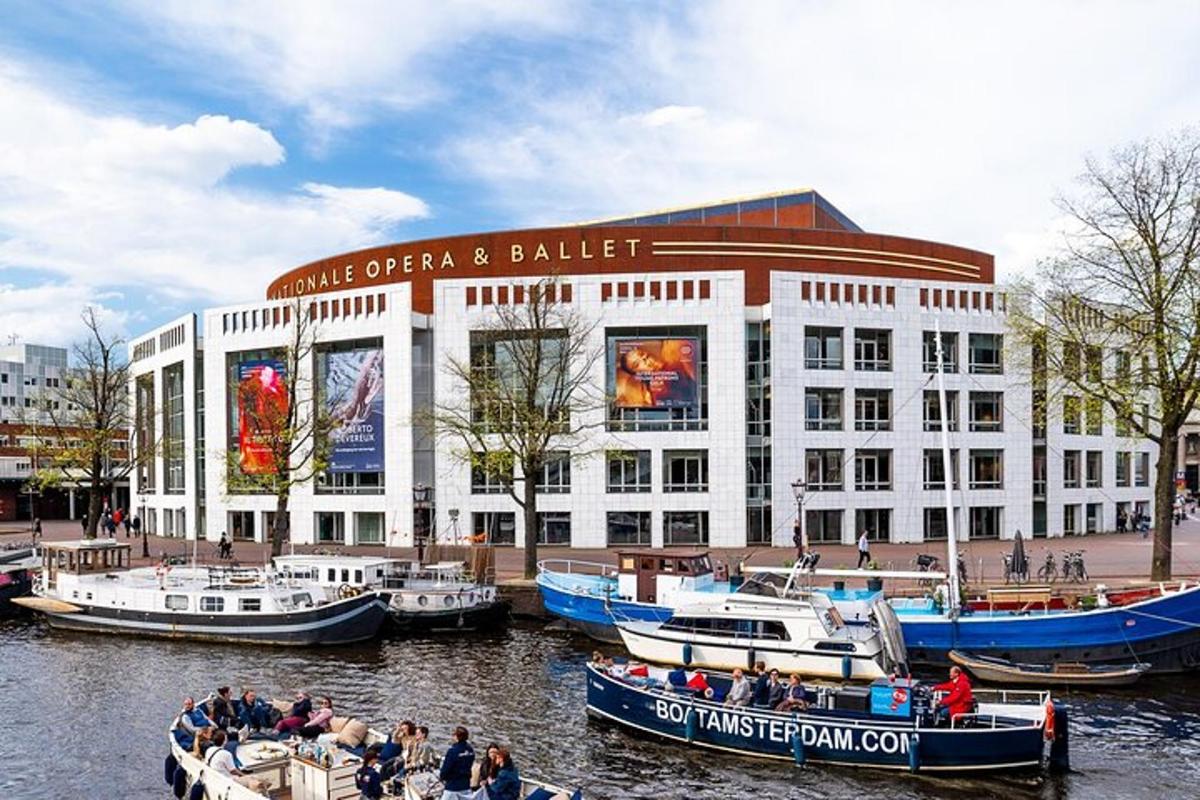 Un gran edificio blanco con barcos en el agua.