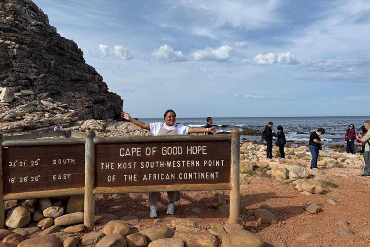 un uomo in piedi dietro un cartello sulla spiaggia