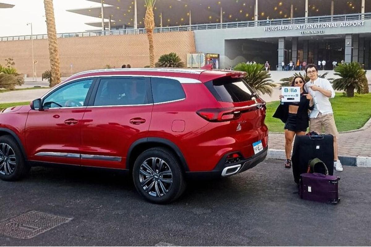 un uomo e una donna in piedi accanto a un SUV rosso