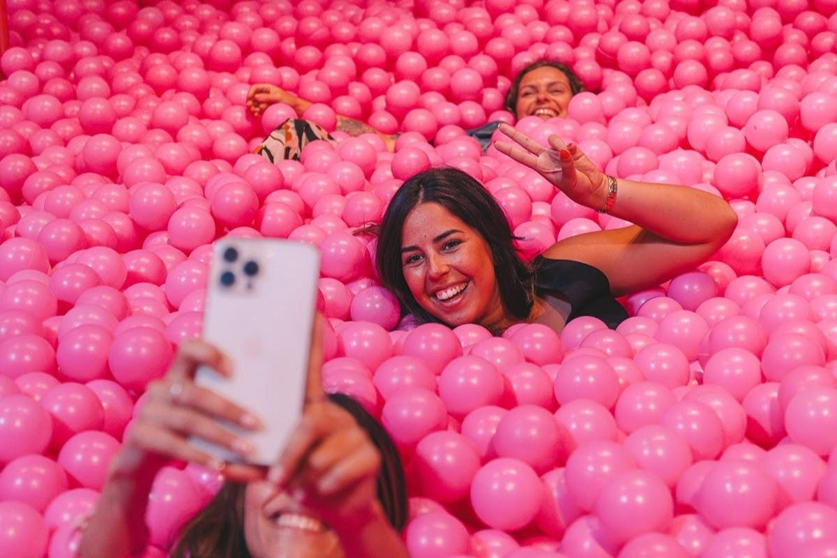 due donne sdraiate su un mucchio di palline rosa