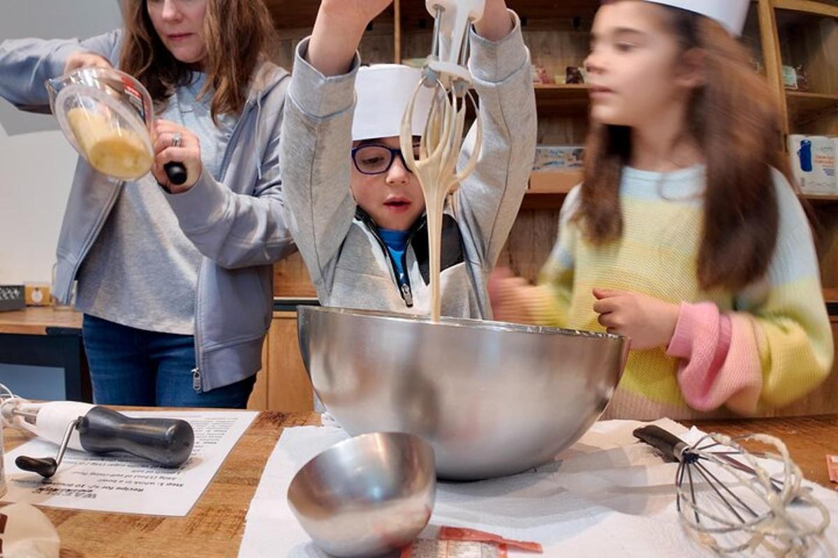 a group of children in a kitchen preparing food in a bowl