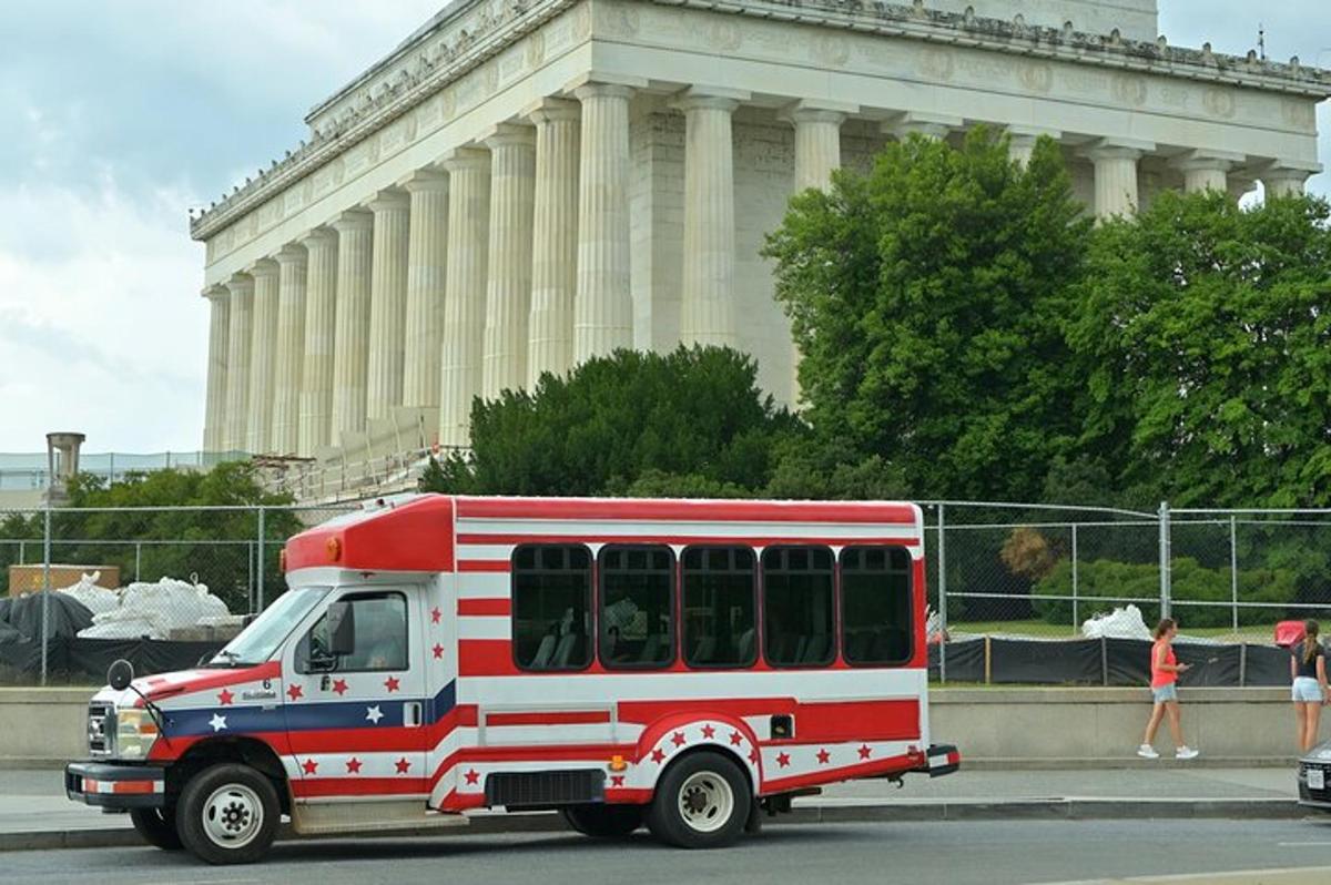 a red and white bus parked in front of a building