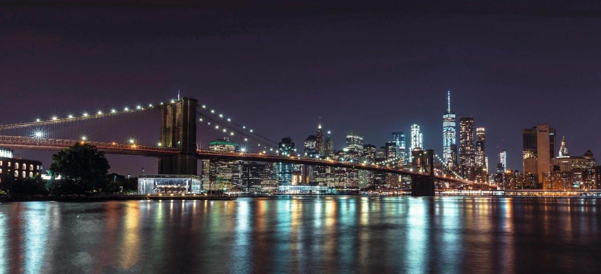 a bridge over the water with a city at night