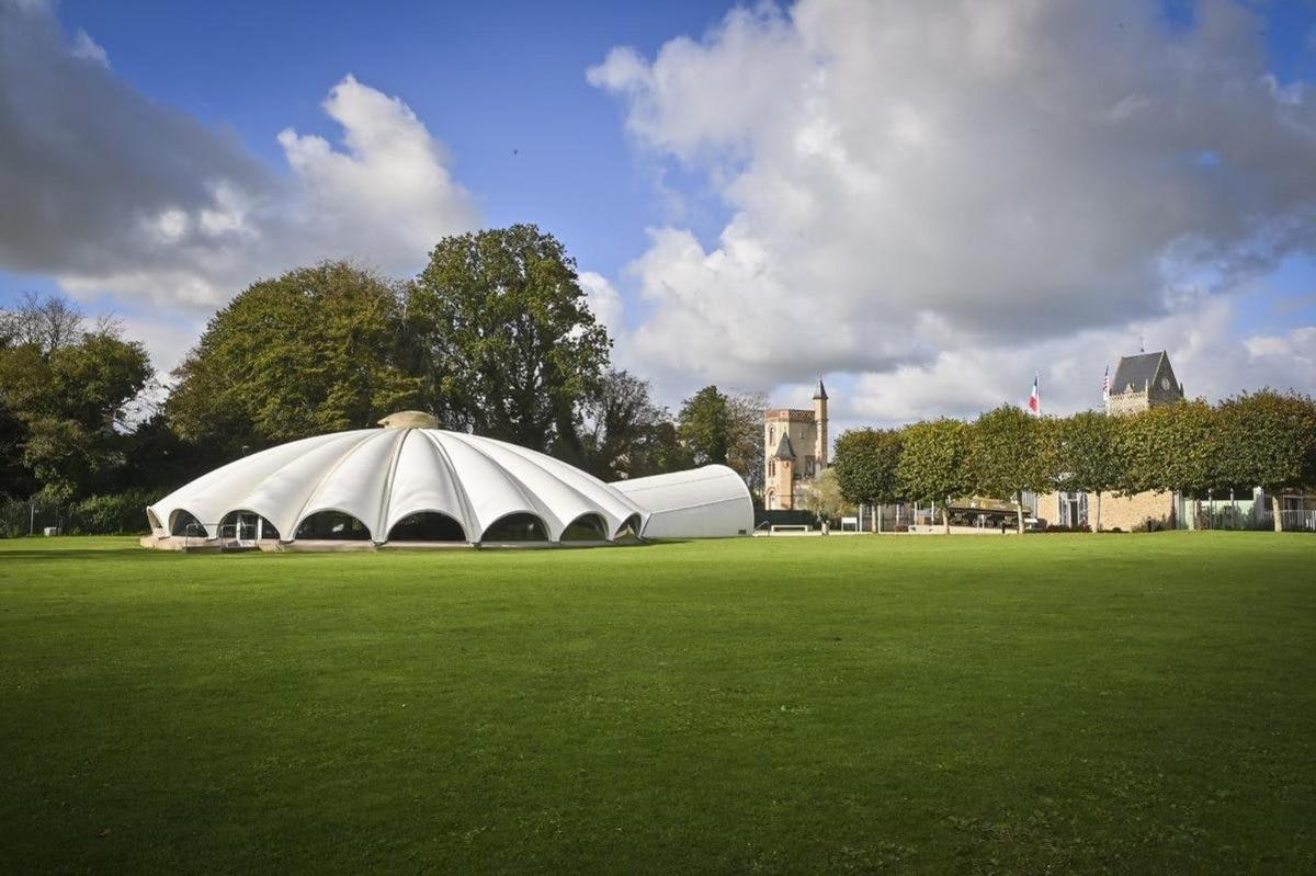 a large white tent in a field of grass