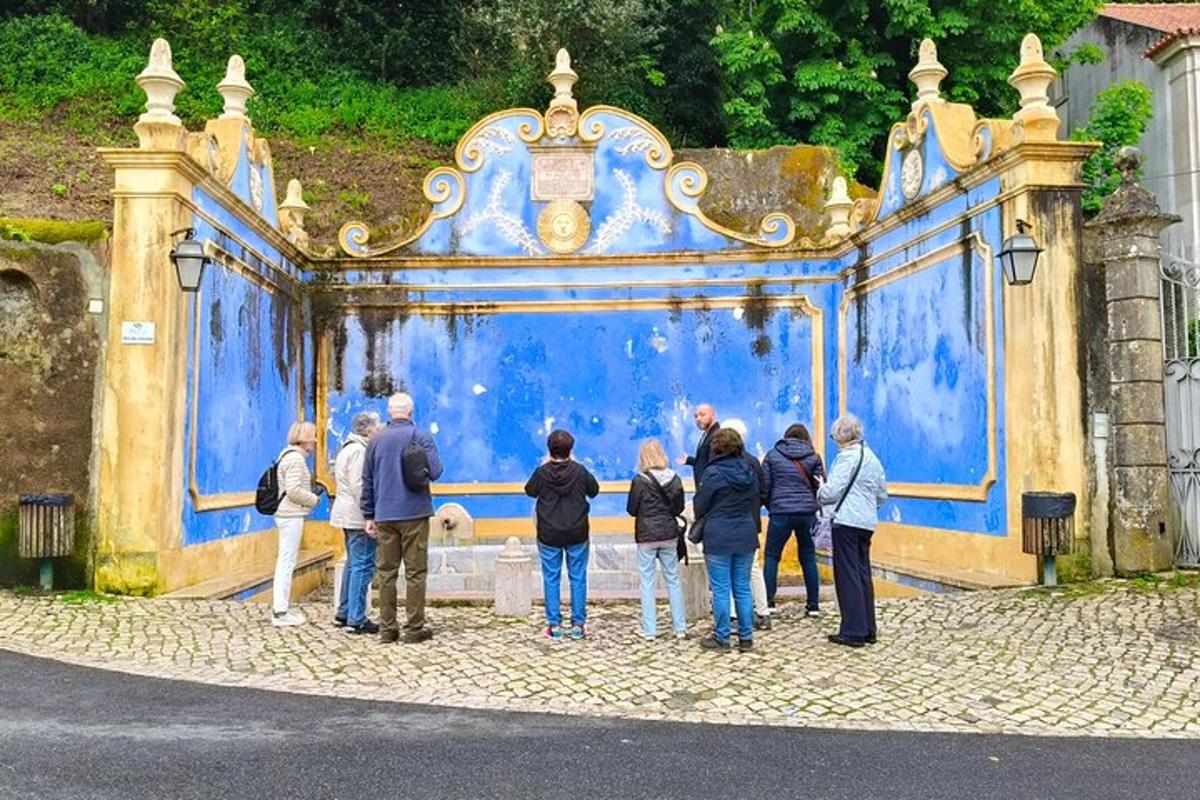 grupė žmonių, stovinčių priešais mėlynus vartus