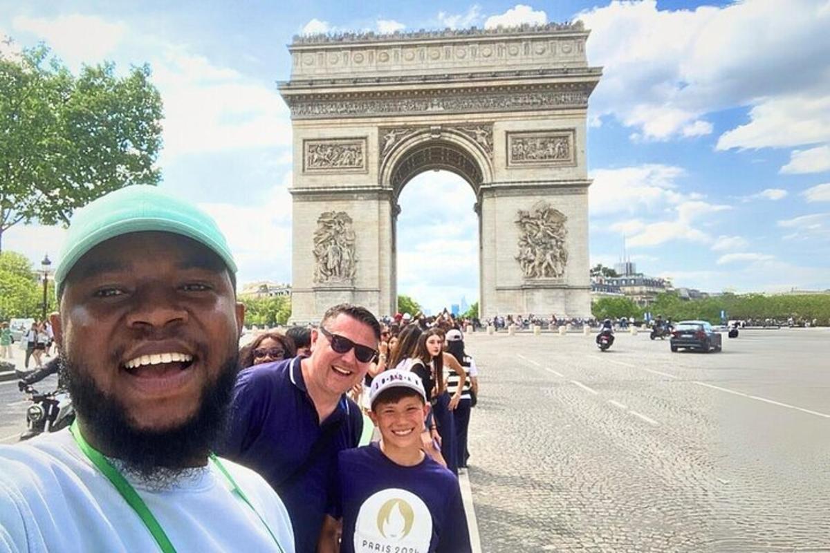 un gruppo di persone in piedi davanti all'arco di trionfo
