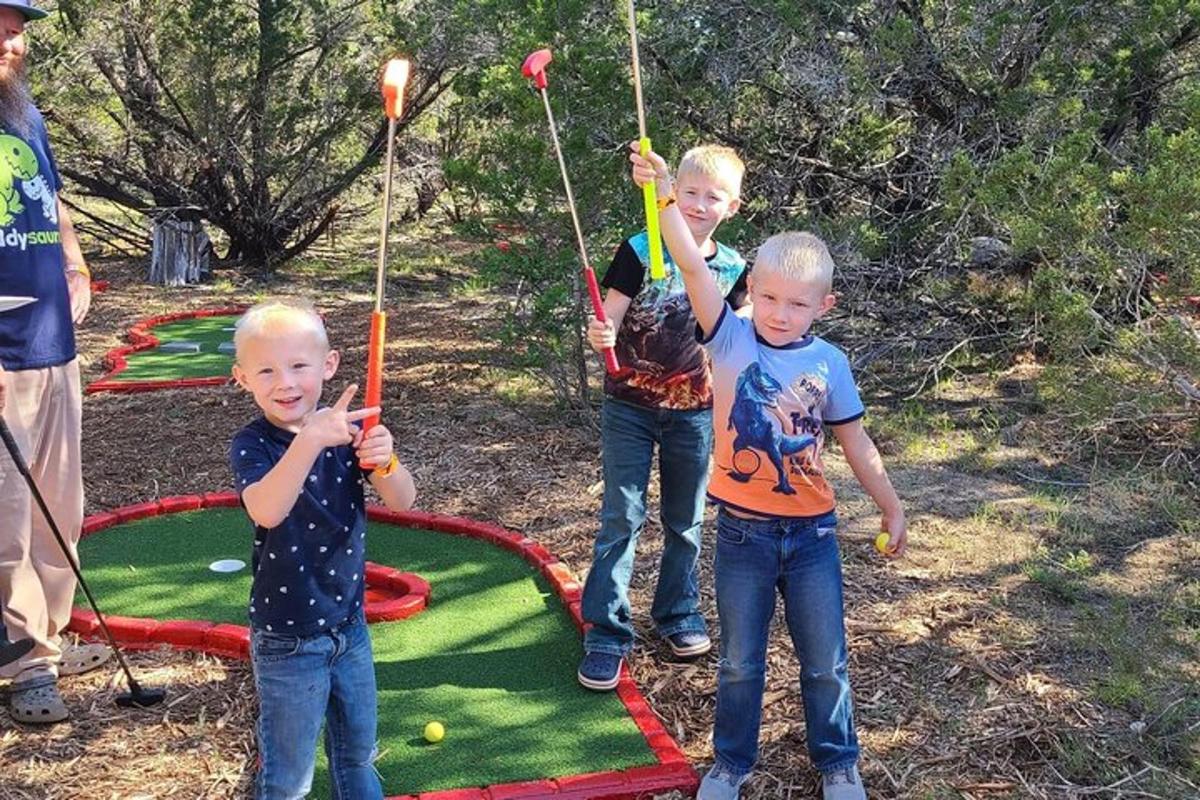 three young boys playing with balls on a trampoline