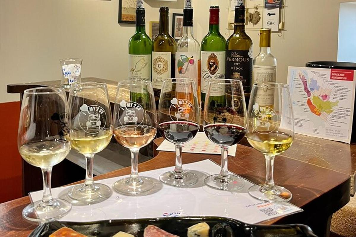 un grup de pahare de vin pe o masă cu sticle de vin