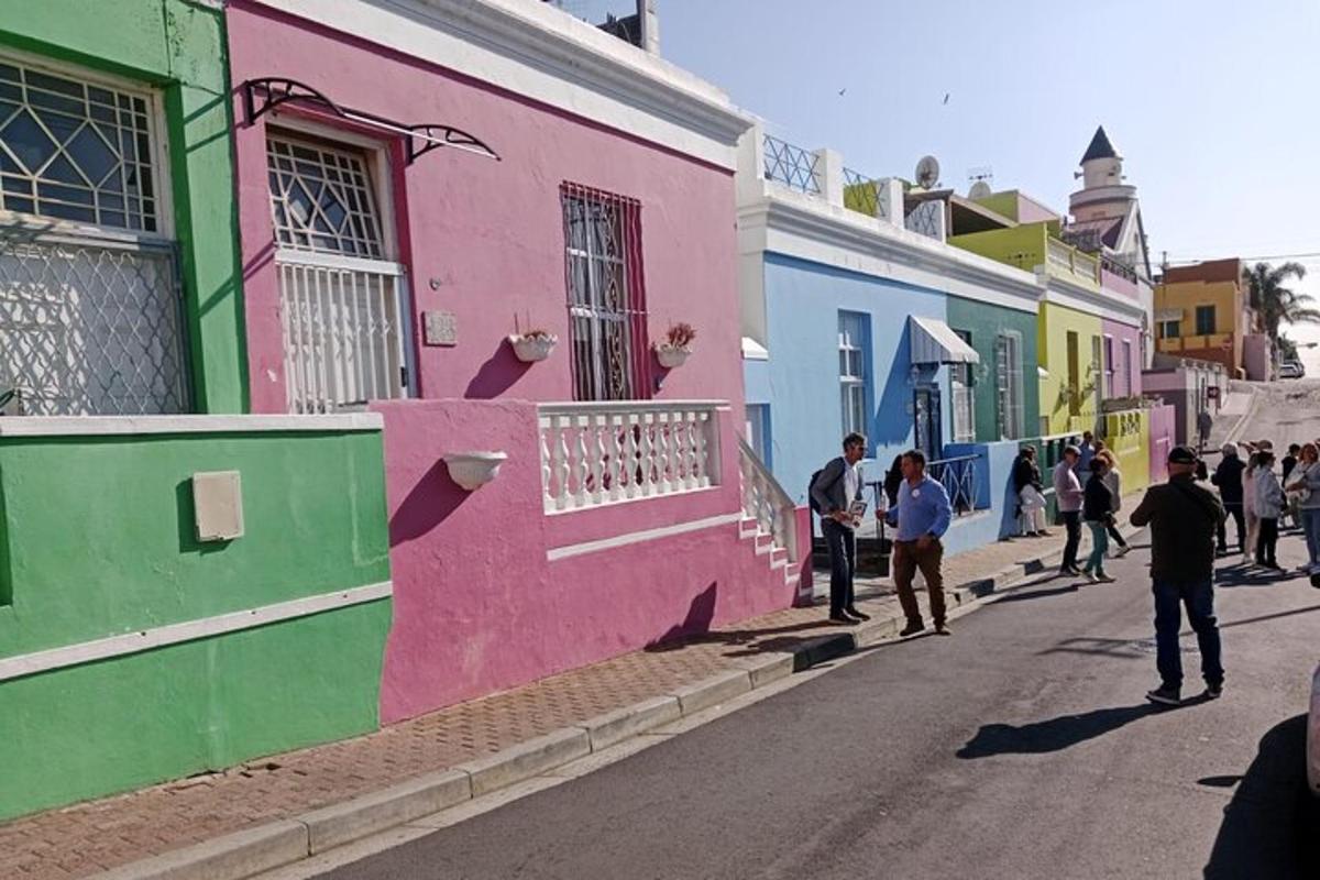 un gruppo di persone che camminano lungo una strada con edifici colorati
