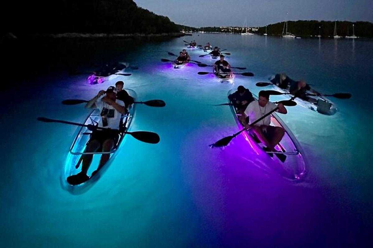 un gruppo di persone in kayak sull'acqua di notte