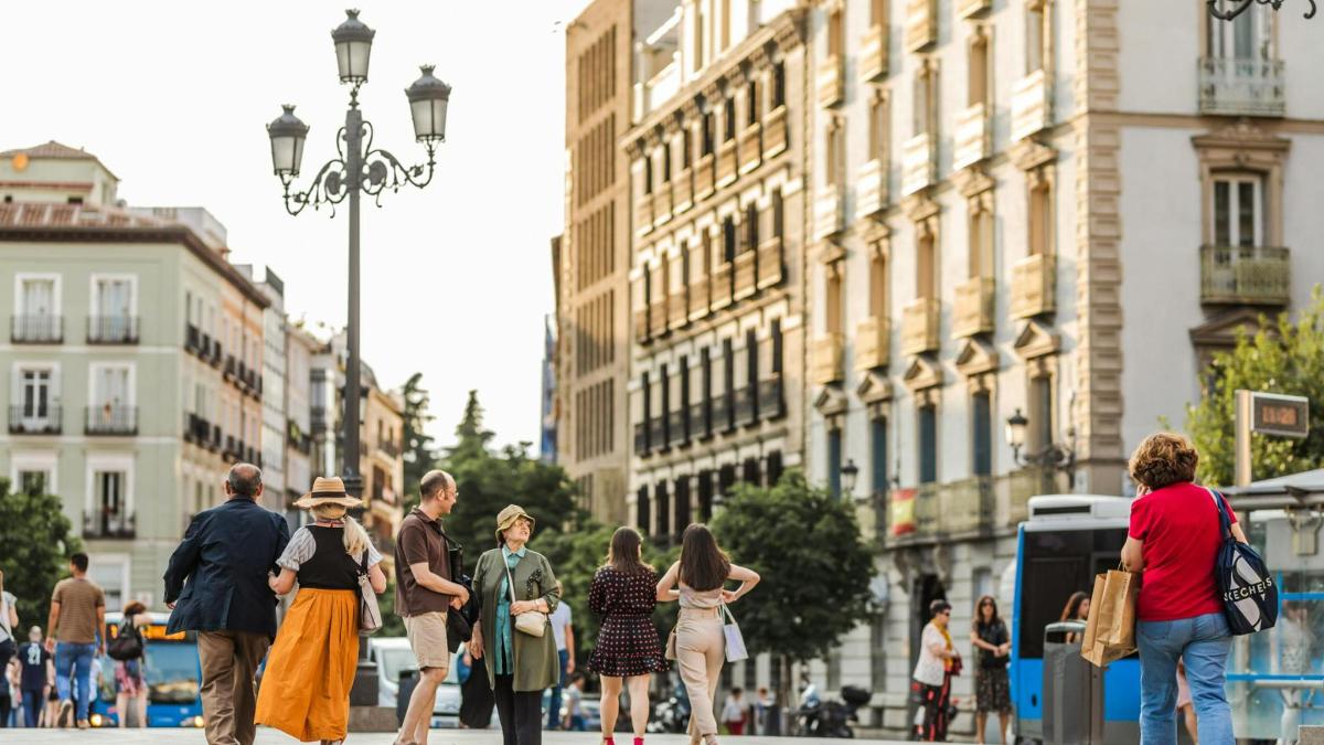 un grup de persones caminant per un carrer concorregut de la ciutat
