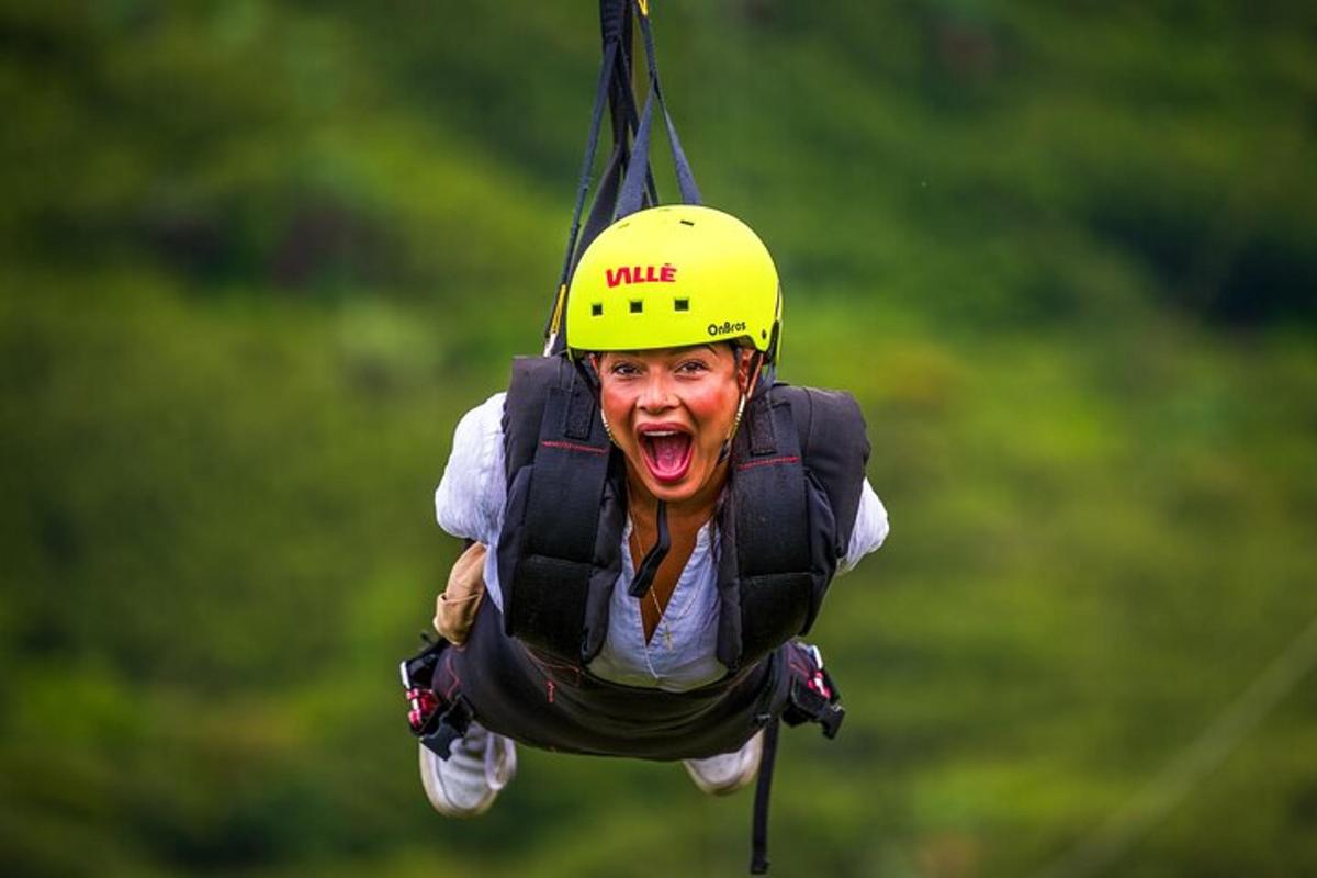 a woman in a yellow helmet hanging from a rope
