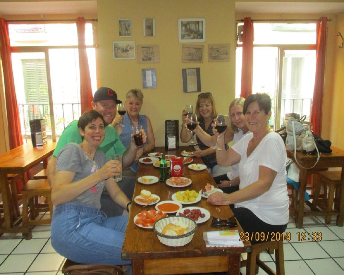 um grupo de pessoas sentadas ao redor de uma mesa bebendo vinho